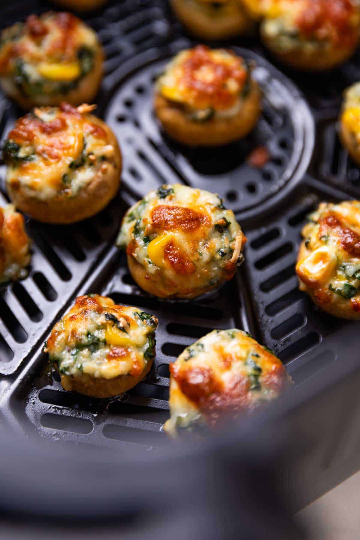 freshly baked air fryer stuffed mushroom lined up in the air fryer