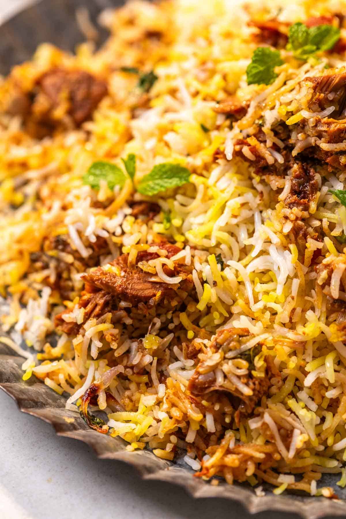 a close up image of jackfruit biryani garnished with mint leaves to show it's fluffy texture