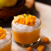 mango sago topped with mango chunks served in a small glass bowls