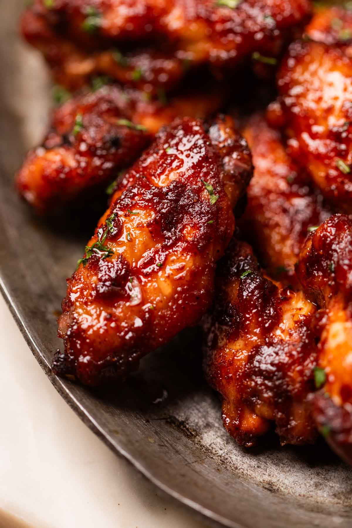 a close up image of air fryer spicy bbq chicken wings to show it's color and texture