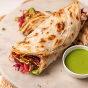 2 anda parathas served on a platter with green chutney