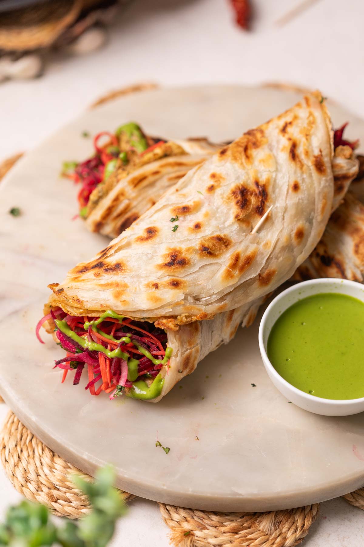 2 anda parathas served on a platter with green chutney