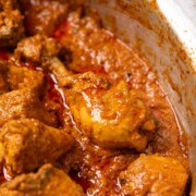 a close up image of chicken korma to showcase it's creamy and juicy texture