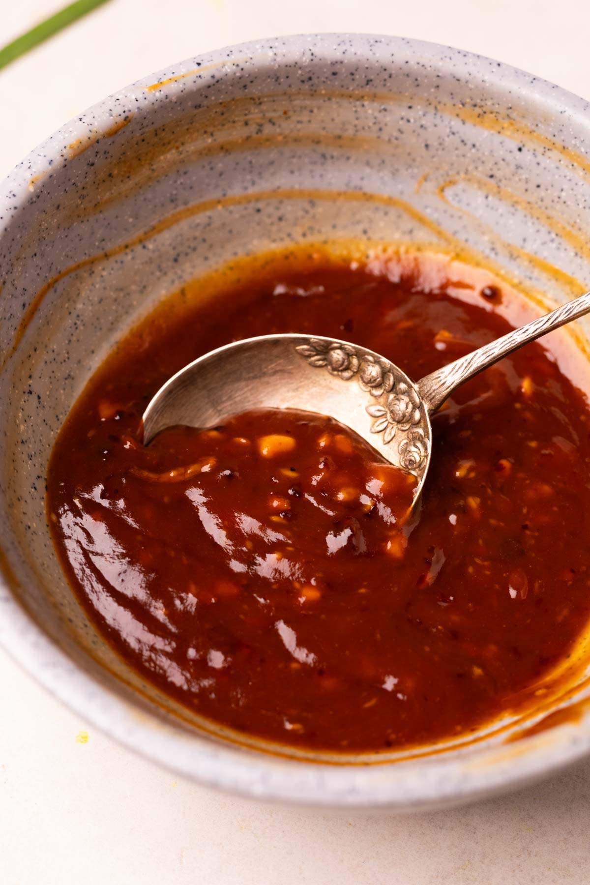 an image of the chilli chicken noodles sauce in a bowl with spoon