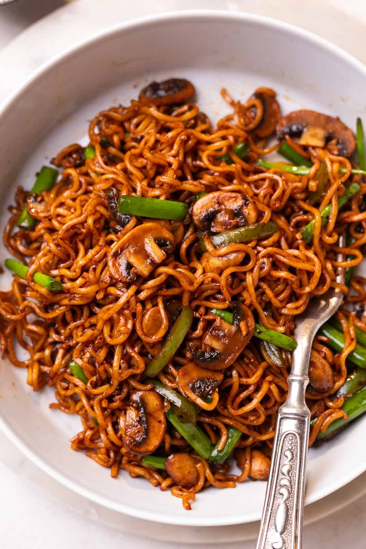 mushroom ramen noodles served in a white dish with a fork