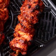 An image of freshly cooked air fryer chicken tikka still in the air fryer basket