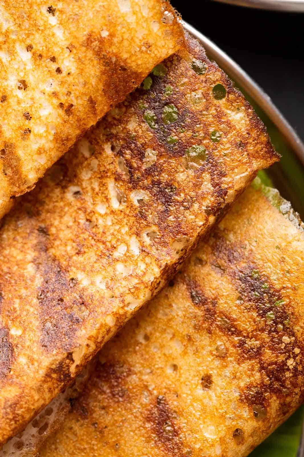Closeup of dosas to show the crispy lacy texture thats a beautiful golden brown in colour