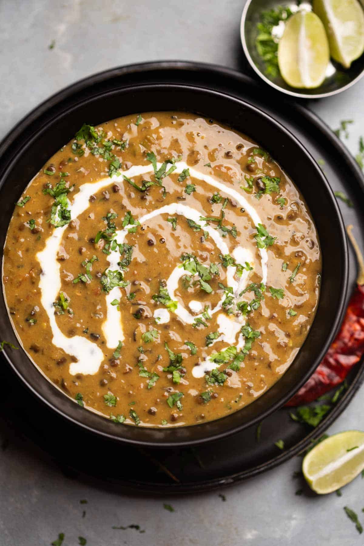 Amritsari dal drizzled with cream and coriander in a black bowl