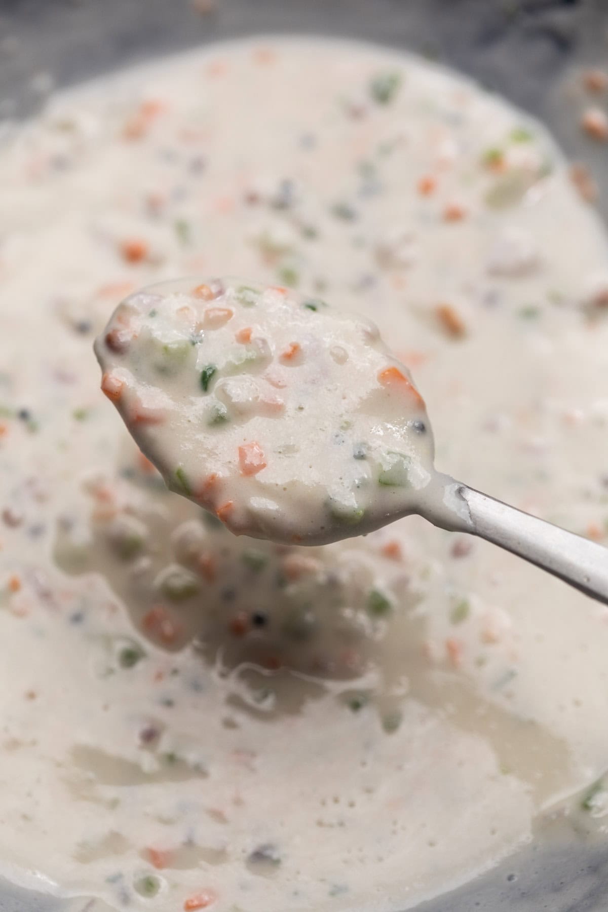 Paniyaram battar scooped up in a spoon to show it's texture and consistency