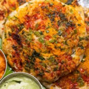 uttapams served with chutneys on a banana leaf platter