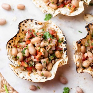 edible papad bowls filled with peanut chaat and served on a white platter