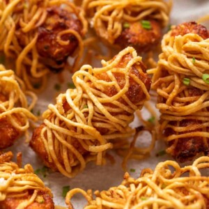 Many pieces of thread paneer served on a tissue paper lined plate