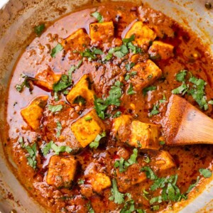 Dhaba style paneer masala in a kadhai with a wooden ladle