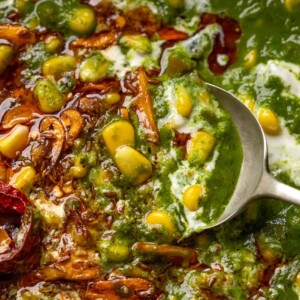 Spoon going into corn palak to show the texture and garlic tadka