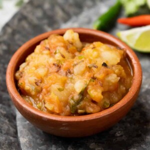 Picture of potato curry served in a brown terracotta bowl