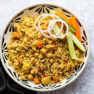 Kabuli Chana Pulao served in a bowl with onions and a salad