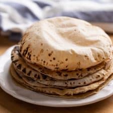 Soft puffy rotis stacked on a plate
