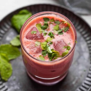 beetroot chaas with ice cubes served in a glass on a metal tray