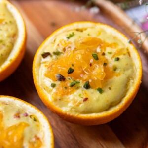 a close up of orange makhana pudding served in orange peel bowls