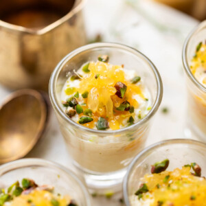 Orange kalakand served in shot glasses and topped with orange segments and chopped nuts