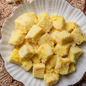saffron milk pudding bites served in a white bowl