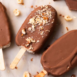 healthy chocobar ice creams garnished with chopped nuts and placed on a white platter