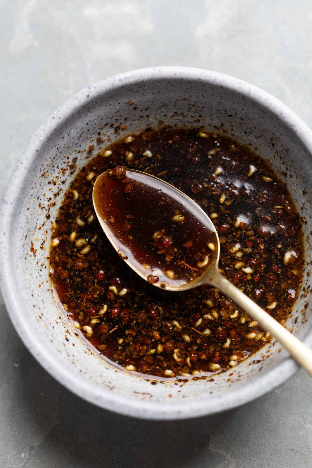 sauce for black pepper chicken in a bowl with spoon