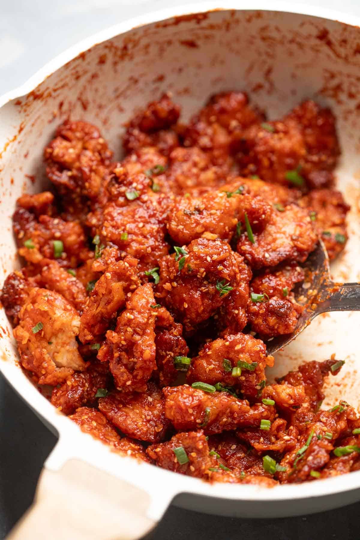 honey garlic chicken being tossed in a pan 