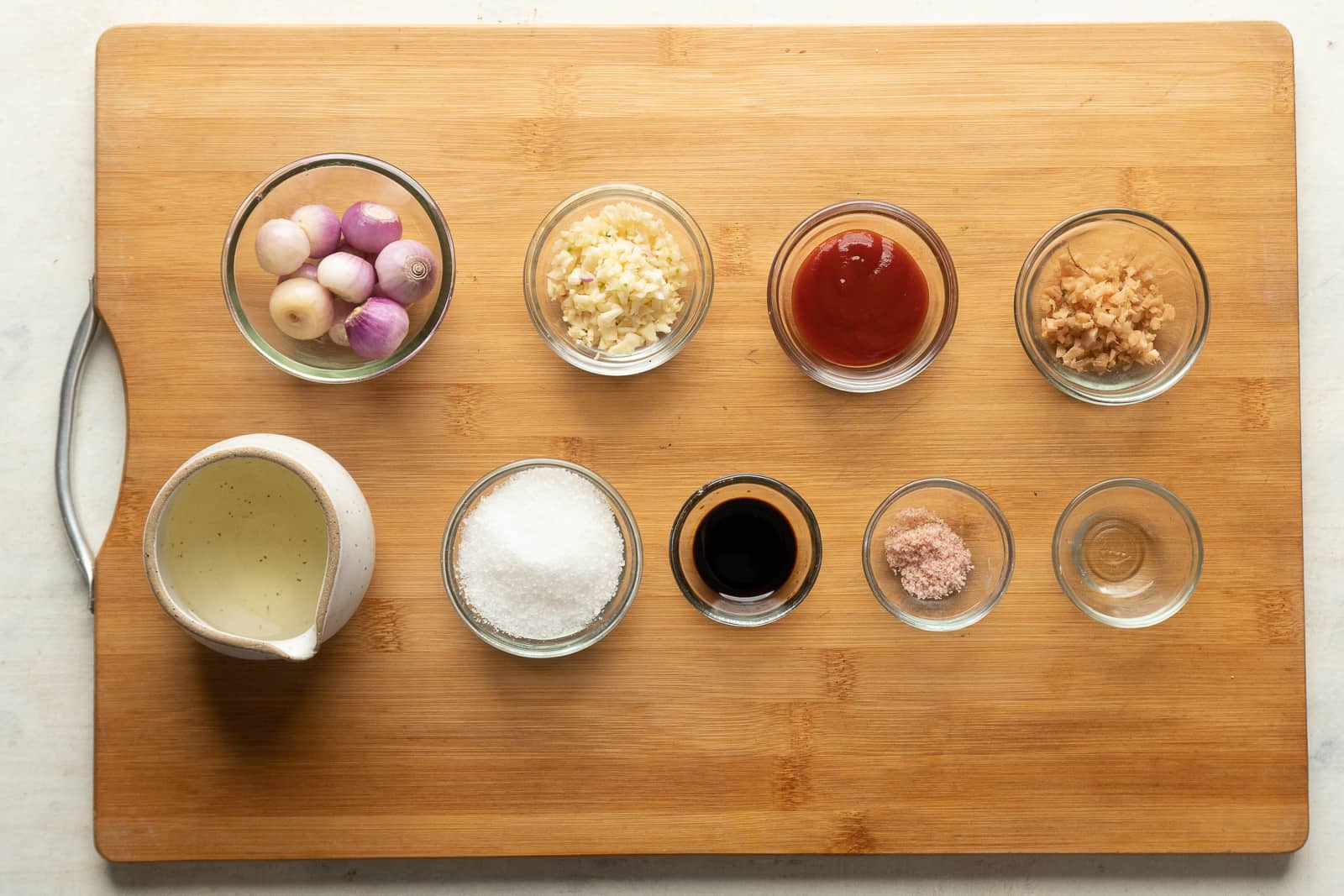 All the ingredients required for schezwan sauce are pictures on a wooden board, except chillies and hot water