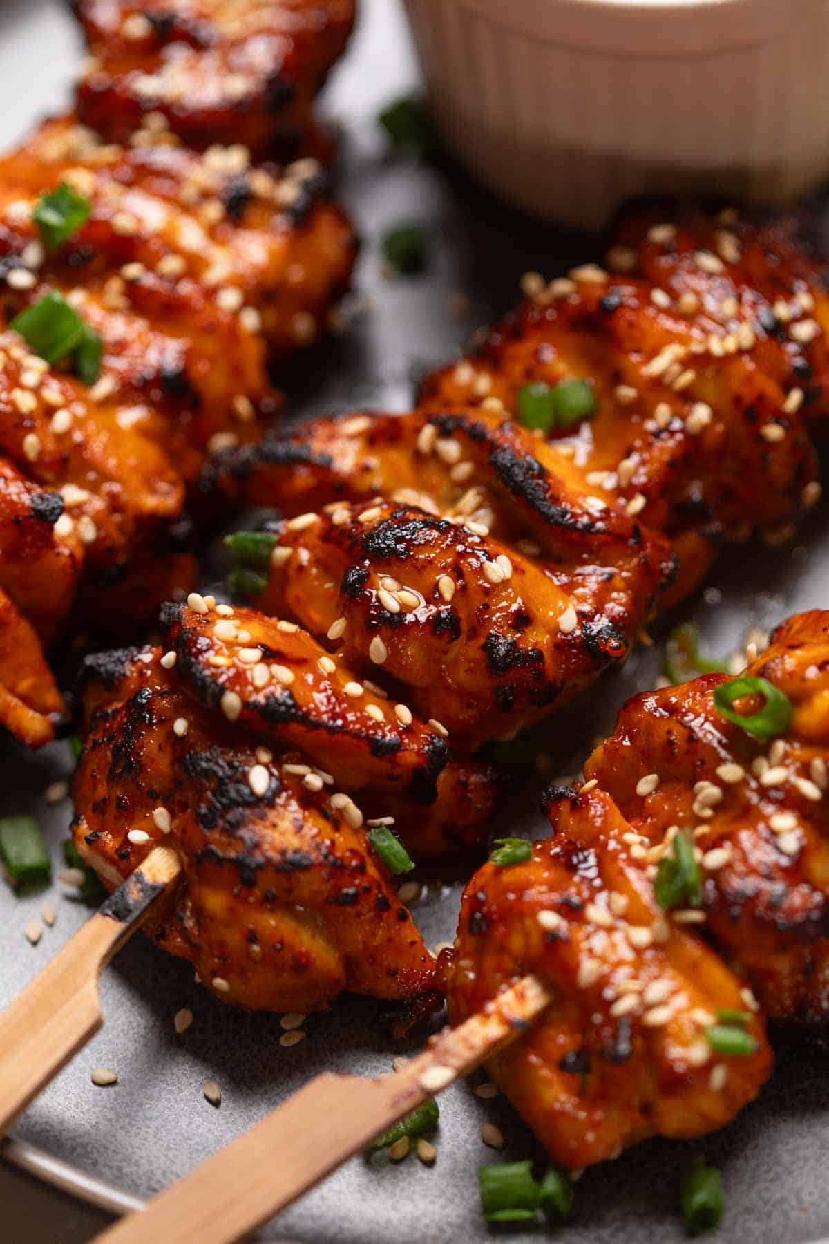 A close up image of bang bang chicken skewers to showcase their crispy, smokey texture