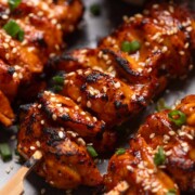 A close up image of bang bang chicken skewers to showcase their crispy, smokey texture