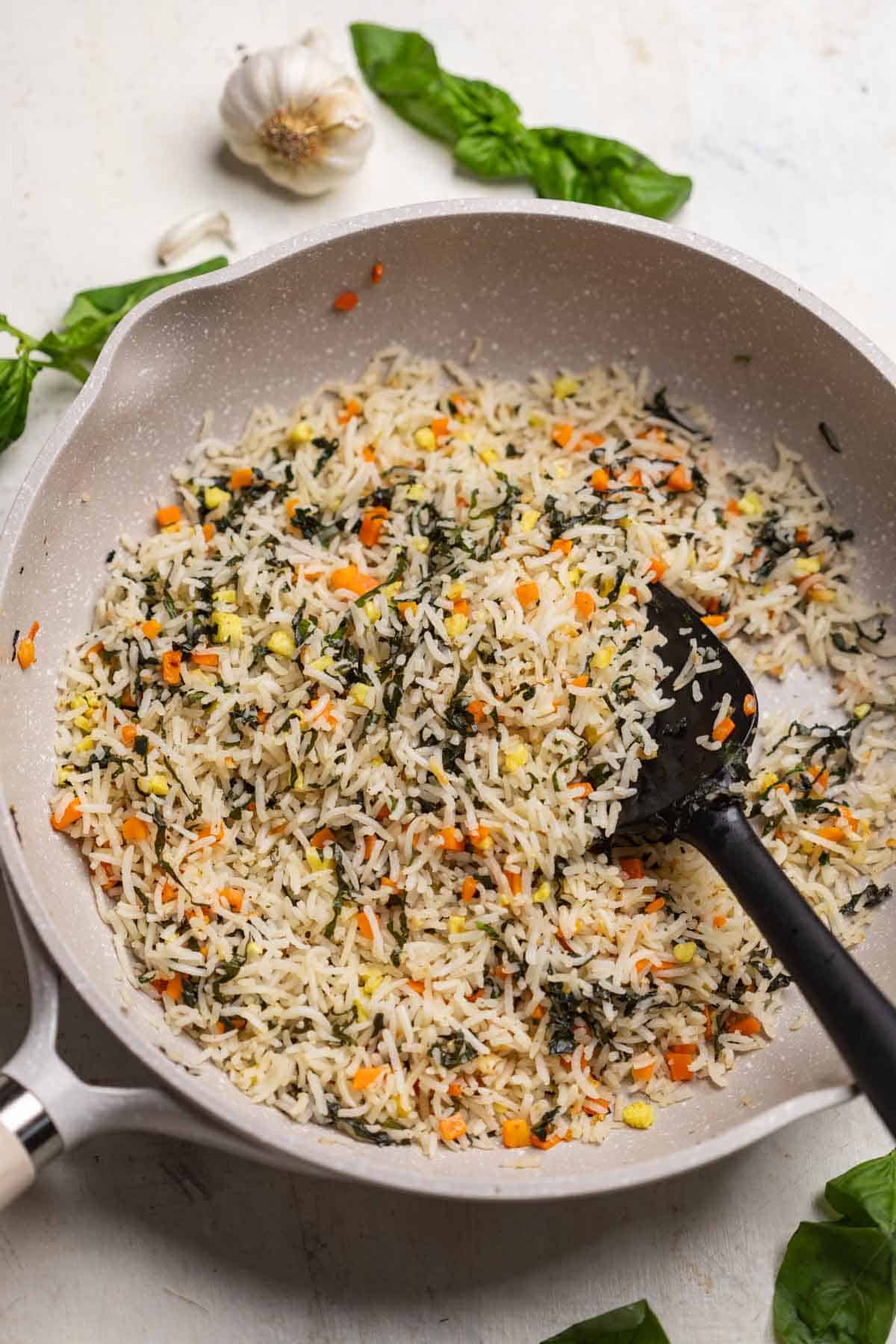 freshly cooked basil fried rice in the frying pan with a spatula