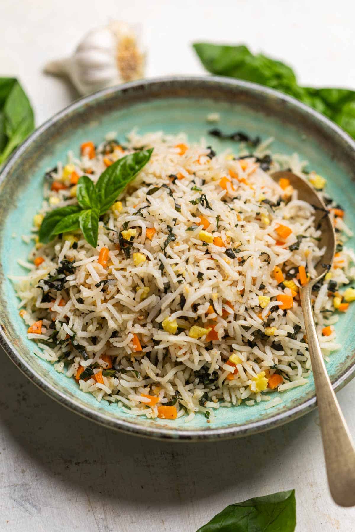 basil fried rice served on a green plate with a spoon