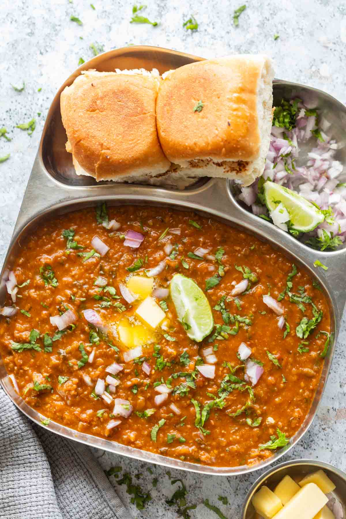 pressure cooker pav bhaji served on a sectioned plate with accompaniments