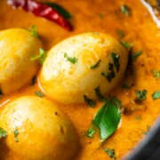close up image of south indian style egg curry to show the creamy texture and perfectly boiled eggs