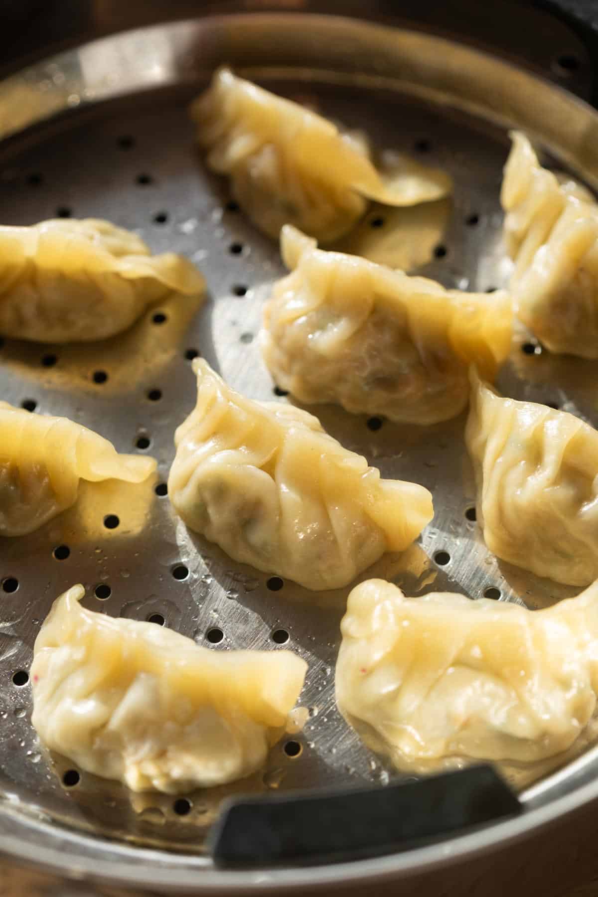 freshly steamed chicken momos placed in the steamer