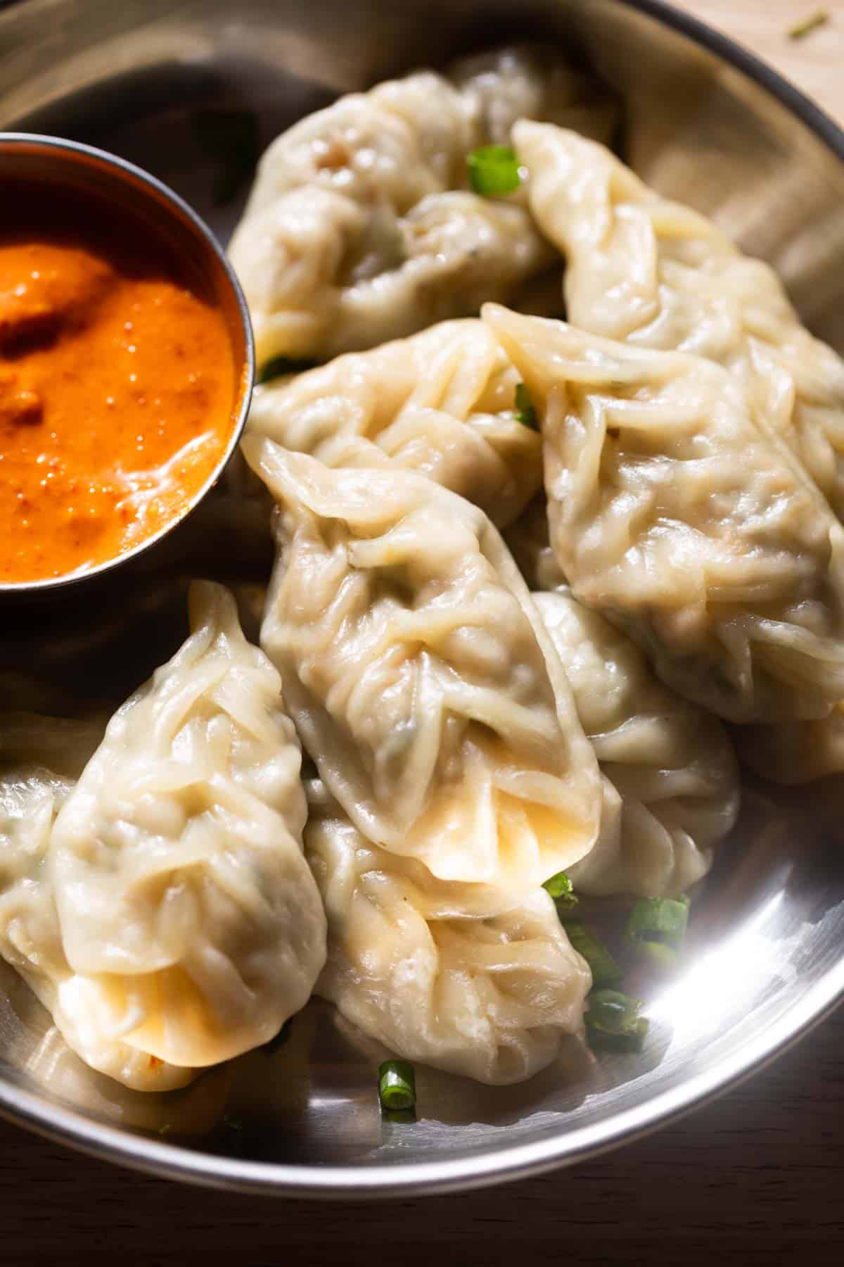 an image of veg momos served with a dipping chutney