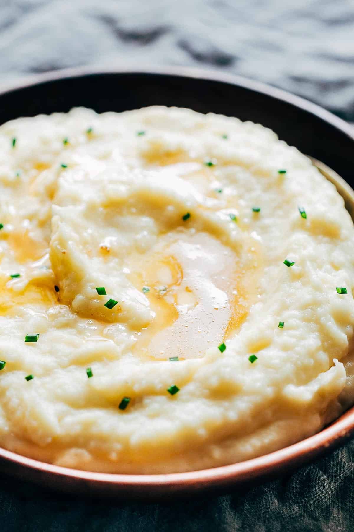 Mashed potatoes flavored with garlic and served in a wooden bowl.