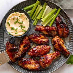 Spicy BBQ Chicken Wings on a hammered silver plate with aioli and celery on the side