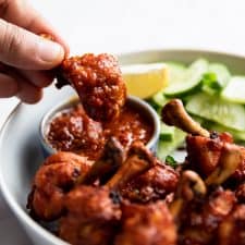 Dipping chicken lollipop in schezwan sauce