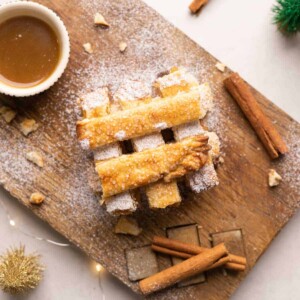 Apple Pie Chips stacked on a wooden board with salted caramel sauce.