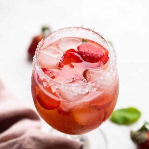 Strawberry Pepper Gin and Tonic served in a short stemmed glass with sugar on the rim