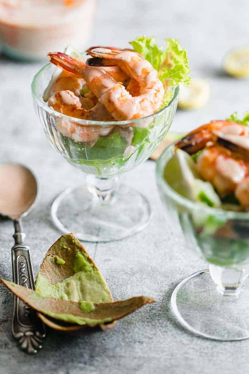 Retro prawn cocktail served in stem glasses with marie rose sauce drizzled over them