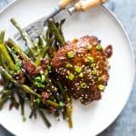 Spicy Korean Chicken Thighs in Gochujang Sauce served on a white plate.