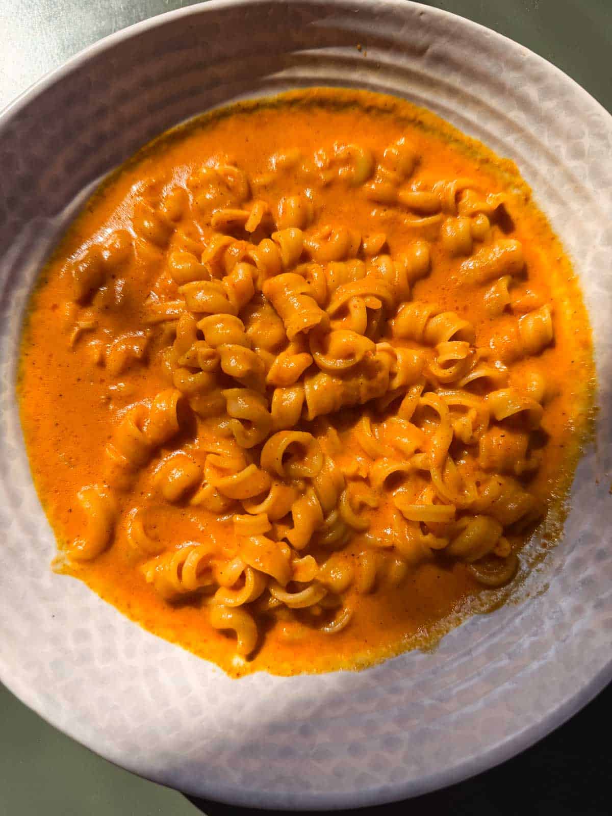 red pepper pasta served in a white bowl