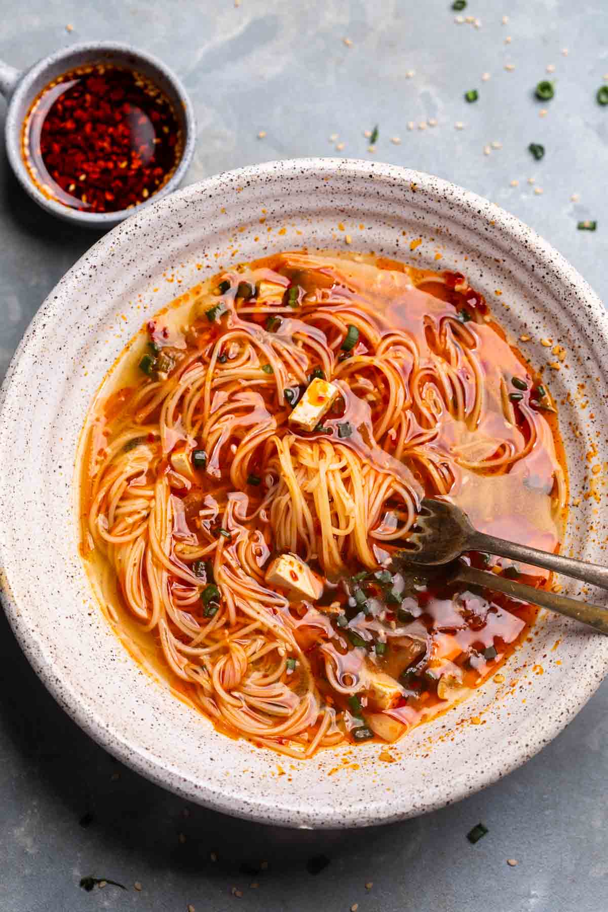 Delicious spicy ramen noodles with tofu, green onions, and chili oil, served in a rustic bowl. Perfect for comforting Asian-inspired meals.