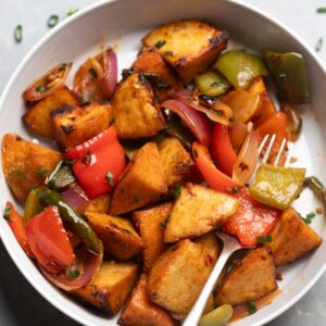 freshly made idli fry served in a white bowl with a fork