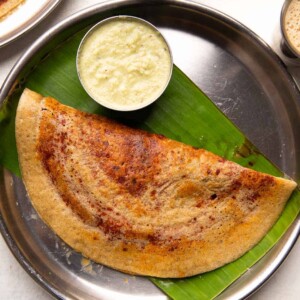 Millet mysore masala dosa served on a steel plate with chutney and filter coffee
