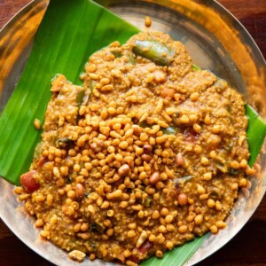 Millet bisi bele bath served on a plate lined with banana leaf