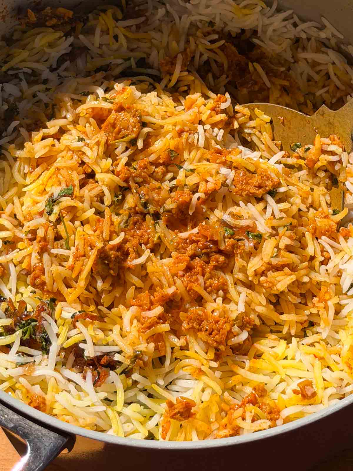 Close up of a big spoonful of soya keema biryani to show the texture of soya granules and basmati rice